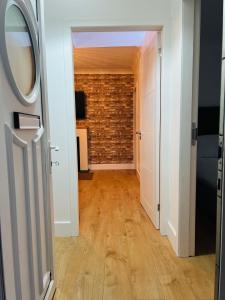 un corridoio con muro di mattoni e porta aperta di Whiteley's Cottages a Dumbarton