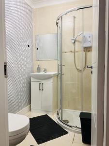 uma casa de banho com um chuveiro, um WC e um lavatório. em Whiteley's Cottages em Dumbarton