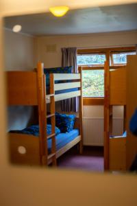 Zimmer mit Etagenbett, 2 Etagenbetten und einem Fenster in der Unterkunft Aviemore Youth Hostel in Aviemore