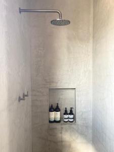 a shower with three bottles on a shelf in a bathroom at T h e L o f t - Stunning private apartment in Perth