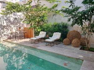 a table and chairs next to a swimming pool at TIKUL EN Merida HISTORIC CENTER in Mérida