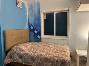 a bedroom with a bed and a window with stars on the wall at Camila In in Philadelphia
