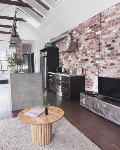 a kitchen with a brick wall and a wooden table at T h e L o f t - Stunning private apartment in Perth