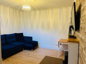 a living room with a blue couch and a table at Whiteley's Cottages in Dumbarton +16 photos
