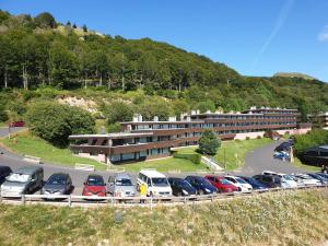 a parking lot with cars parked in front of a building at Studio centre Super-Besse in Besse-et-Saint-Anastaise