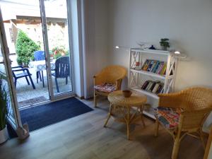 a room with a book shelf and chairs and a table at Ferienwohnung Kerstin in Soltau