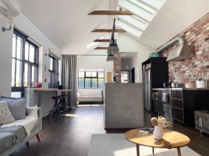 a kitchen and living room with a couch and a table at T h e L o f t - Stunning private apartment in Perth