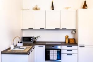 eine Küche mit weißen Schränken und einem schwarzen Gerät in der Unterkunft City center apartment Azura Vista in Poreč