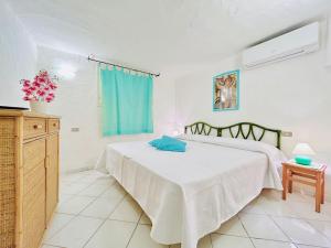 Un dormitorio con una cama con una almohada azul. en Villa Palma, en Baja Sardinia