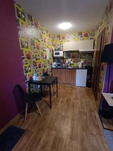 a living room with a table and a kitchen at Apartamenty z ogrodem 2 typu studio in Mrągowo