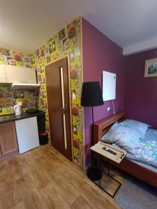 Il comprend une cuisine et une chambre avec un lit et une table. dans l'établissement Apartamenty z ogrodem 2 typu studio, à Mrągowo
