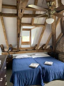 a bedroom with a blue bed with two towels on it at Domaine de Berducq in Monein