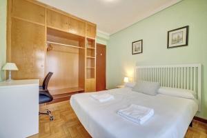 1 dormitorio con 1 cama blanca grande y 1 silla en Te Adoro 11 by Clabao en Pamplona