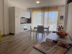 a kitchen and dining room with a table and chairs at Appartamento Dragunara in Alghero