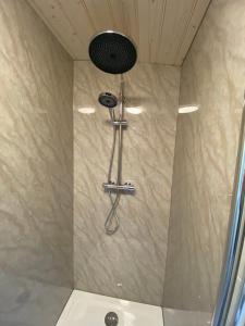 een douche met een douchekop in een badkamer bij Camping Het Vossenhol in Ermelo