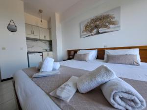 - une chambre avec 2 lits et des serviettes dans l'établissement 75 Steps Apartments, à Mesongi