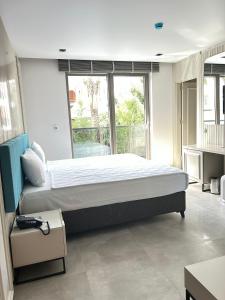 Cette chambre comprend un grand lit et une grande fenêtre. dans l'établissement Sam Hotel, à Antalya
