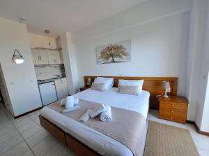 1 dormitorio con 1 cama con toallas en 75 Steps Apartments, en Mesongi