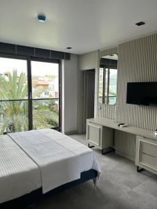 a bedroom with a large bed and a large window at Sam Hotel in Antalya