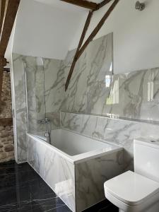 uma casa de banho com uma banheira branca e um WC. em Domaine de Berducq em Monein