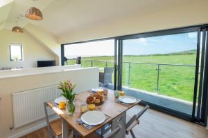 a dining room with a table and a large window at Glan Yr Afon in Llanrhyddlad