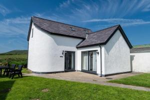a white building with a black roof at Glan Yr Afon in Llanrhyddlad