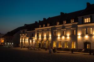 een groot wit gebouw met 's nachts verlichting bij Dom Architekta in Kazimierz Dolny