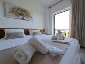 a hotel room with a bed with towels on it at 75 Steps Apartments in Mesongi