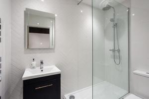 a white bathroom with a sink and a shower at Luxury Apartment Woodsmill View - on the river - with balcony - Recently refurbished in York