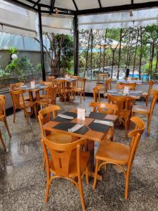 un grupo de mesas y sillas en un restaurante en Condomínio Max Savassi Superior apto 1302, en Belo Horizonte