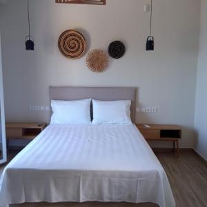 a bedroom with a white bed with two pillows at Zephyros Villas - Agios Nikitas in Kalamitsi