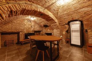 Habitación con mesa de madera y pared de ladrillo. en Salve rooms2 tabidze, en Tiflis