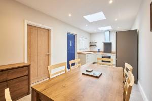 a kitchen and dining room with a wooden table and chairs at Host & Stay - Porter Cottage in Alnwick +12 photos