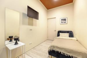 Un dormitorio con una cama y un televisor en la pared. en Salve rooms2 tabidze, en Tiflis