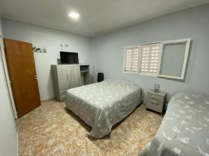 a bedroom with a bed and a desk and a window at Departamento la terminal in General Roca