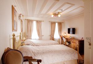a bedroom with two beds and a desk and a tv at Darussaade Hotel Old City - Sultanahmet in Istanbul