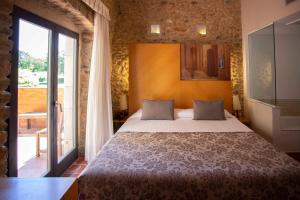 1 dormitorio con cama y ventana grande en Arcs De Monells - Adults Only, en Monells