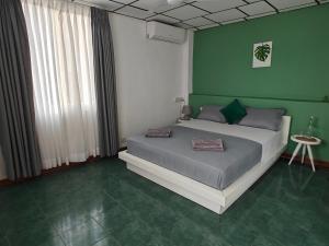 a bedroom with a bed and a green wall at Palmyrah Residencies in Colombo