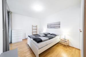 a bedroom with a bed in a white room at Garden Towers Apartments in Prague