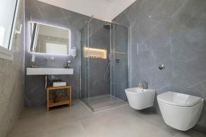 a bathroom with a shower and a toilet and a sink at Case Vacanza Loria in Castelluzzo