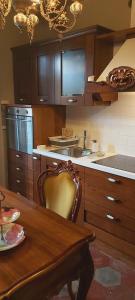 a kitchen with wooden cabinets and a table with chairs at Villa Costanza Appartamento con giardino in Magreglio