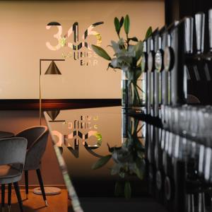 فندق دو لاك  في ليموني سول غاردا: غرفة بطاولة وكراسي وجدار بساعة