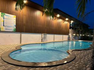 a large swimming pool in front of a building at night at คลิ๊กรีสอร์ท (Click Resort) in Ban Ko Yai Chim (1)