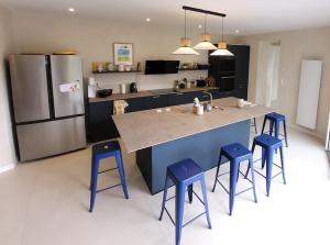 a kitchen with a large island with blue stools at La Vie de Famille - Les Gîtes de la Côte d'Amour in Le Croisic