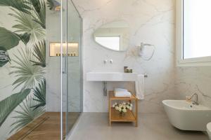a bathroom with a sink and a glass shower at Case Vacanza Loria in Castelluzzo