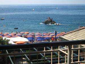 a beach with umbrellas and people in the water at Diana Cosy Apartment sea view near the beach in Monterosso al Mare