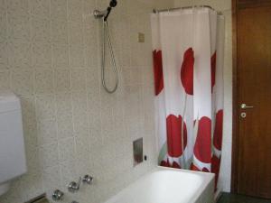 a bathroom with a shower with a red and white shower curtain at Diana Cosy Apartment sea view near the beach in Monterosso al Mare