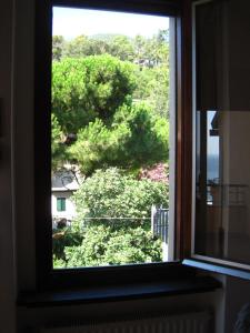 a window with a view of a house and trees at Diana Cosy Apartment sea view near the beach in Monterosso al Mare +8 photos
