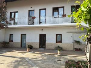a white building with a balcony on top of it at Casa Teddy Torino in Bosconero