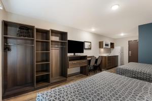 1 dormitorio con 2 camas y escritorio con ordenador en WoodSpring Suites Indio - Coachella Valley, en Indio